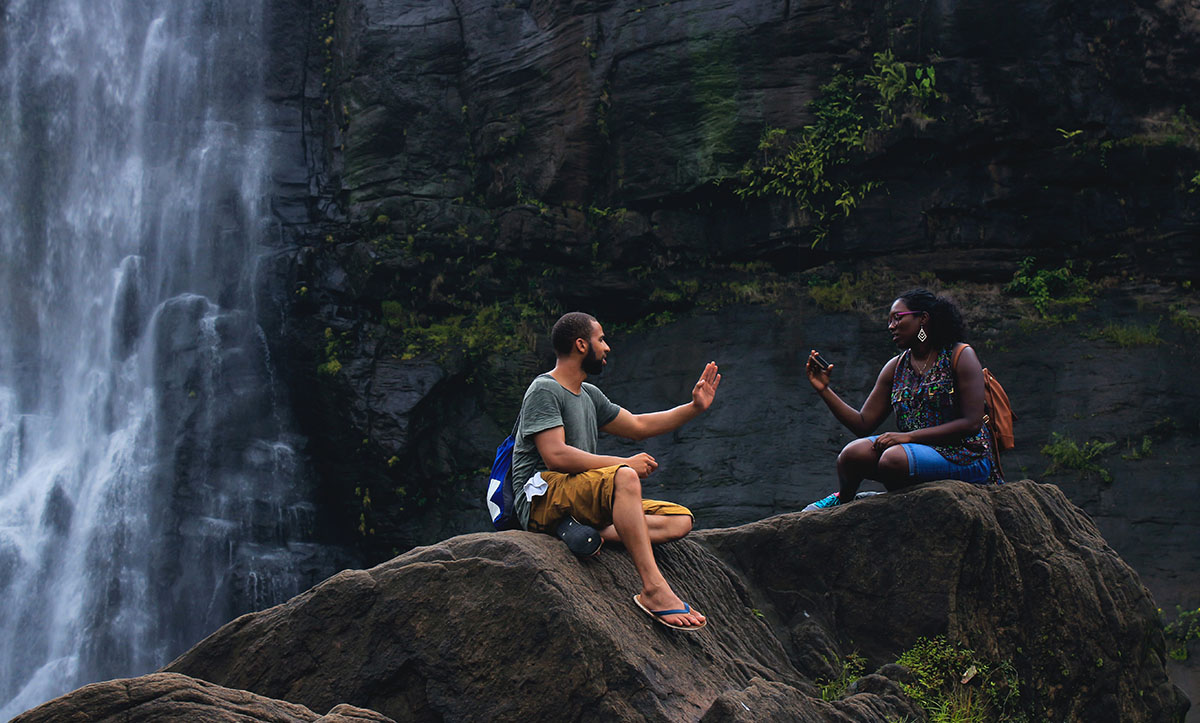 couple sitting by a waterfall couple sitting by a waterfall