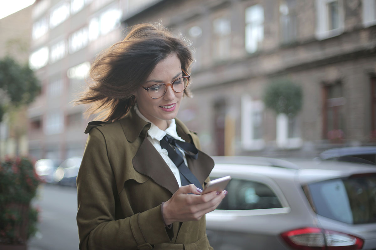 woman walking and looking at her phone