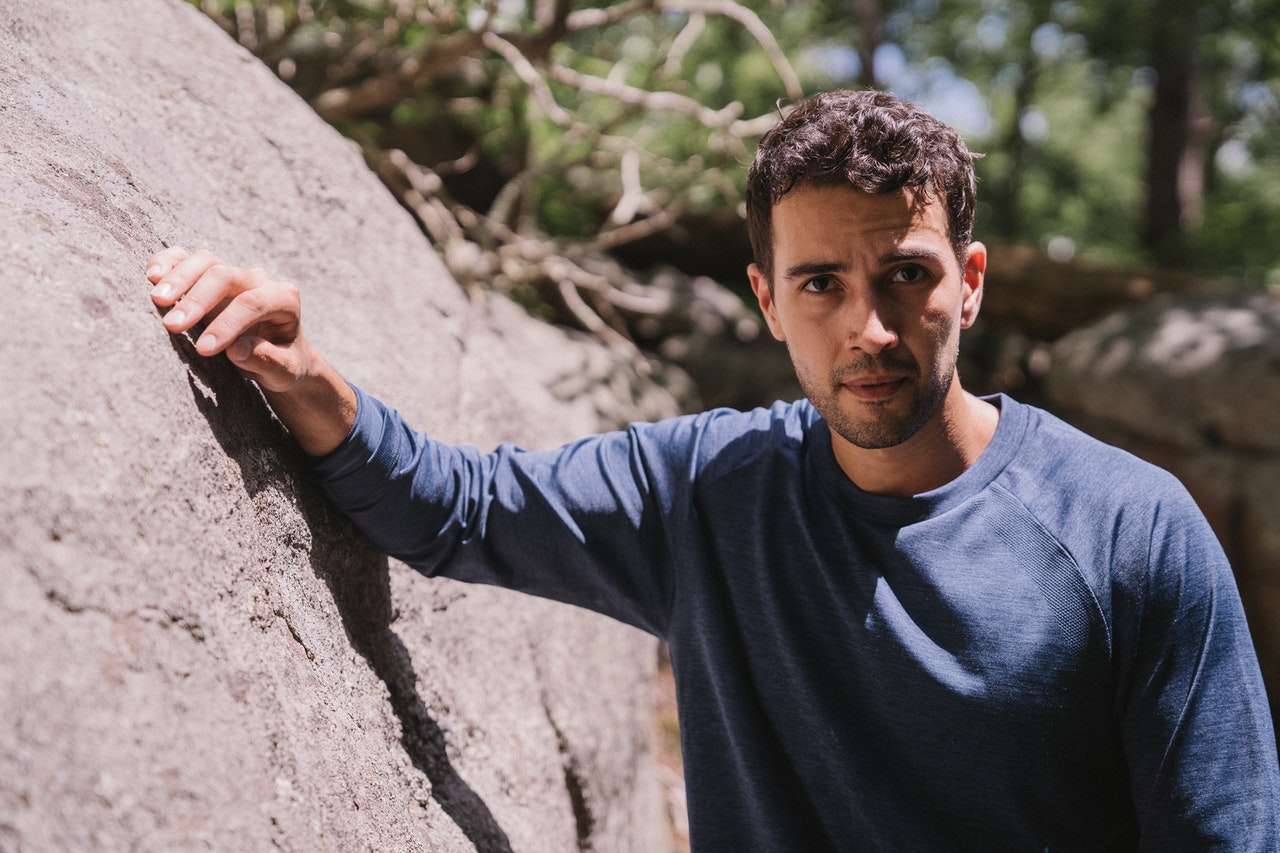 single guy standing against a rock