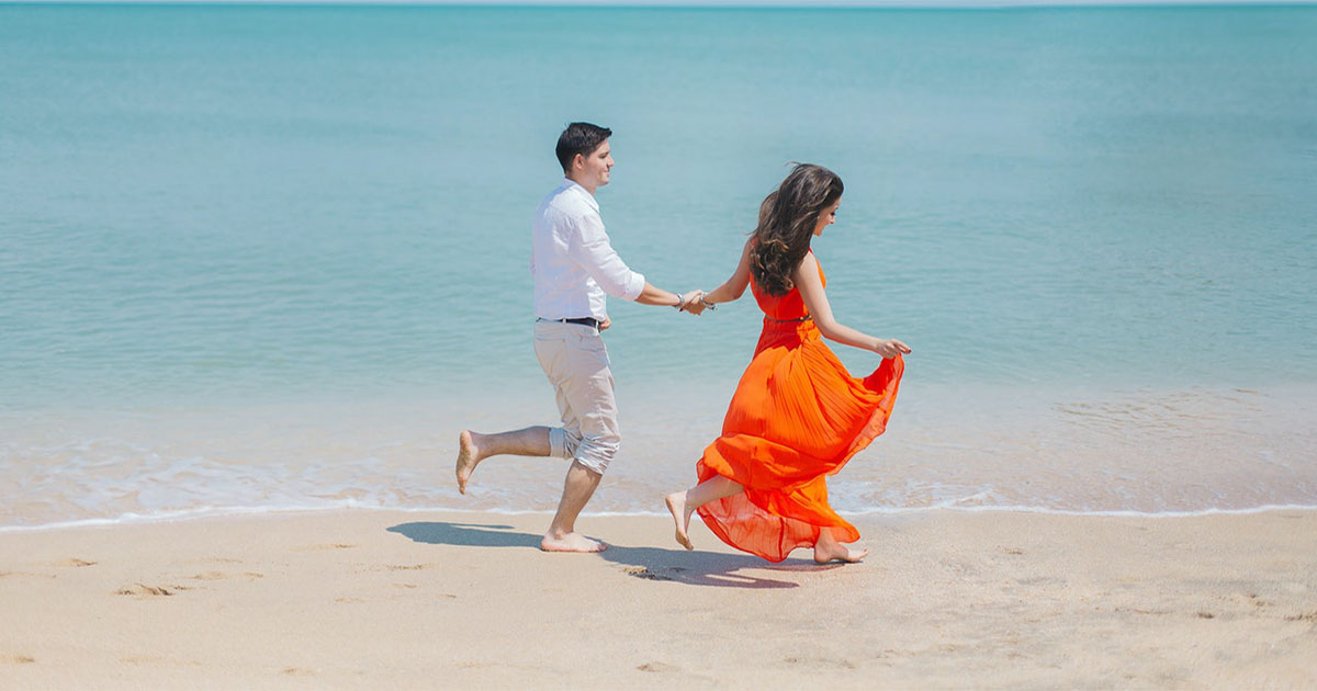 happy couple running on the beach