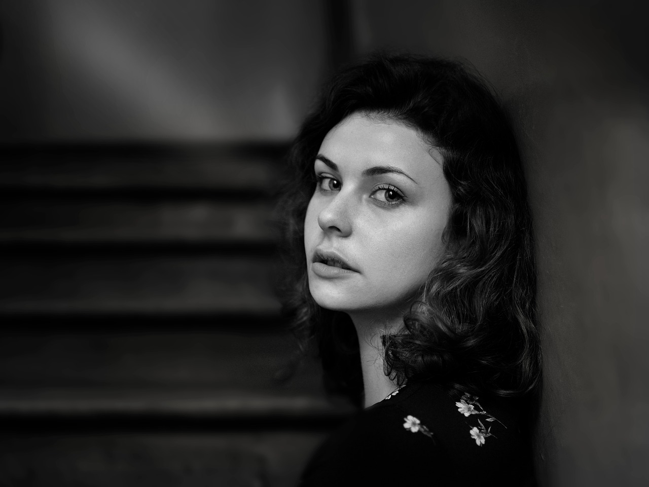 sad woman leaning against a wall