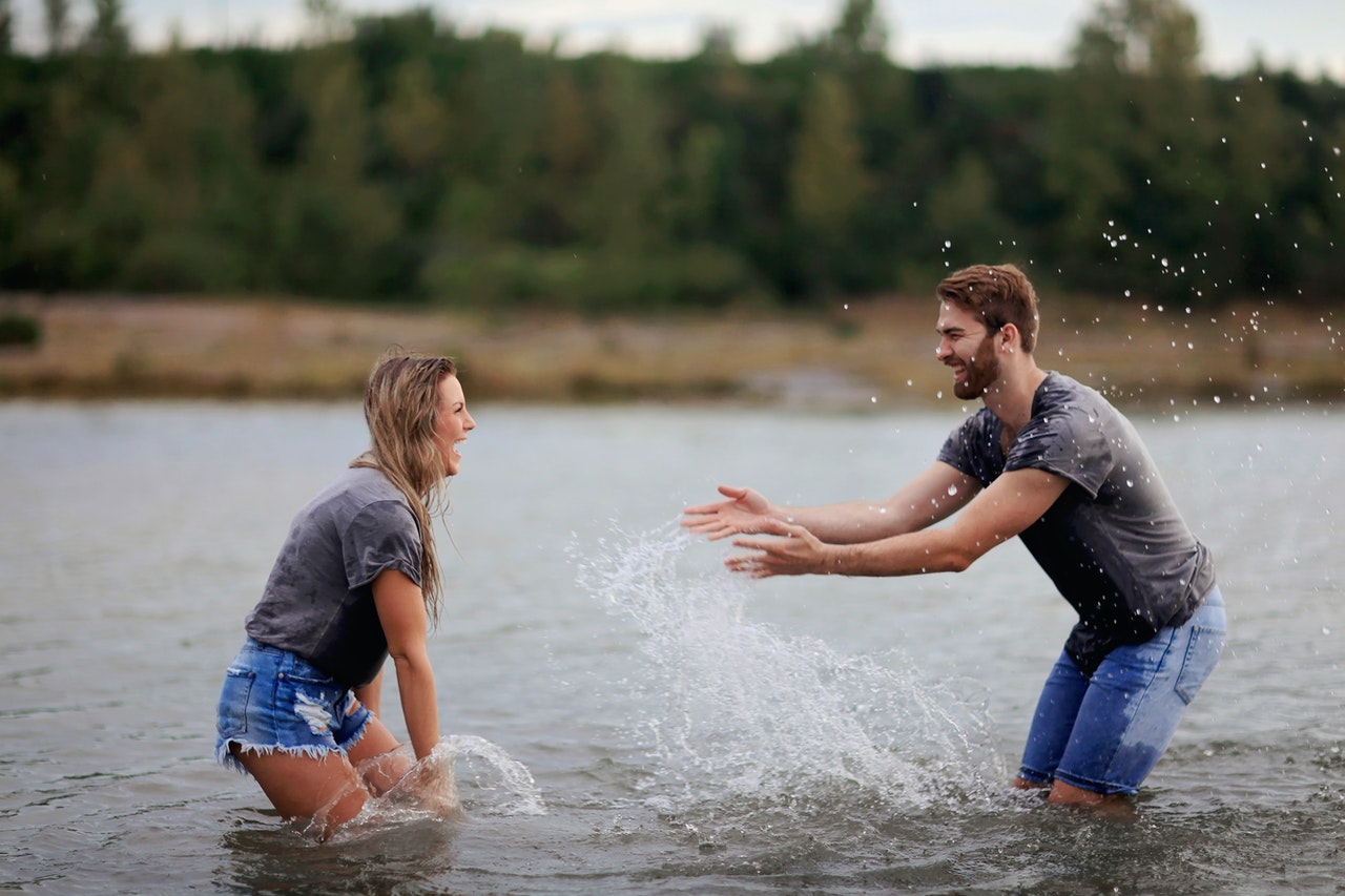 couple splashing water on each other