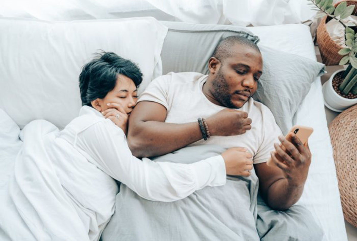 man on his cell phone in bed man on his cell phone in bed