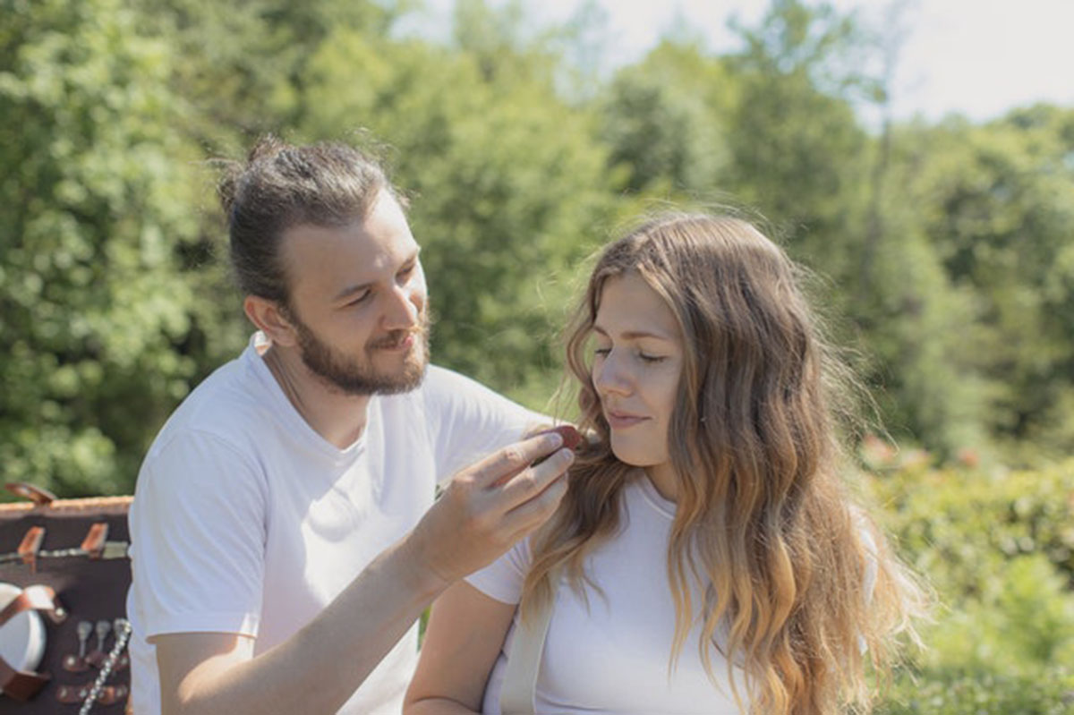 man feeding woman fruit