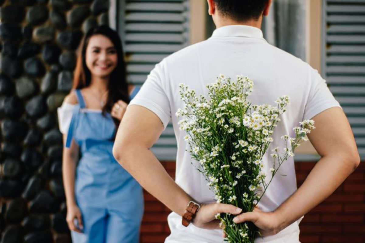 man giving a woman flowers